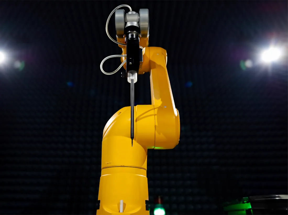 A robotic arm working under spotlights in a darkened room