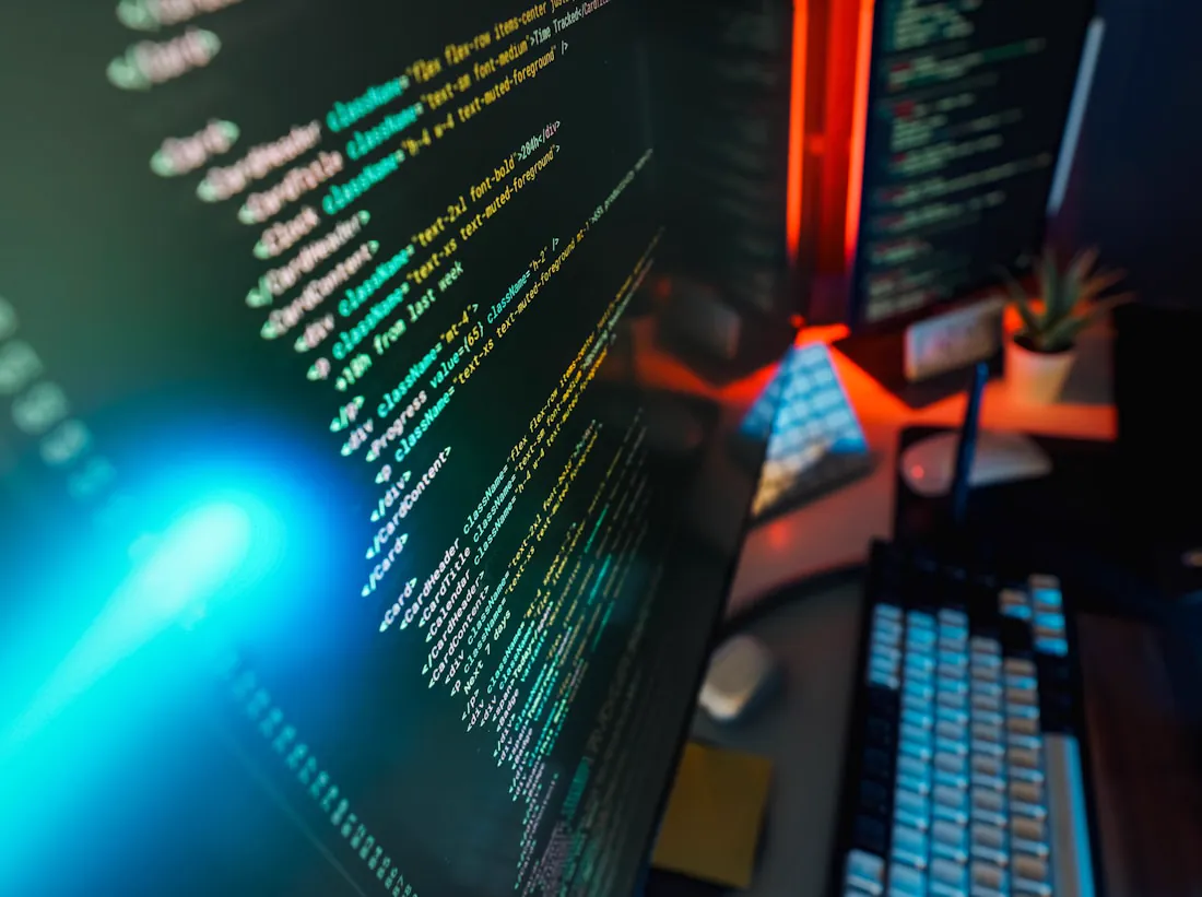 Website code on a monitor in a dark studio lit with warm accent light